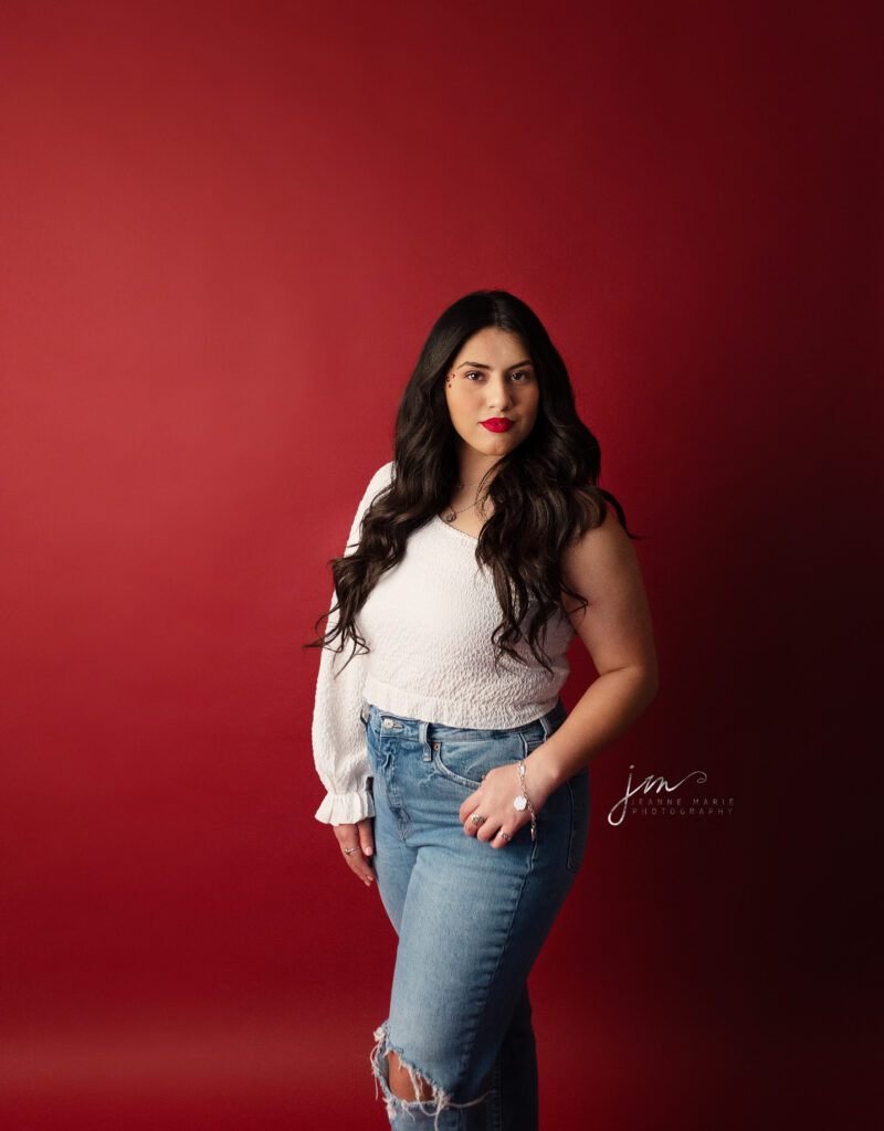 Tulia High School senior in a Valentine studio session. Girl in white shirt against a red savage seamless background 