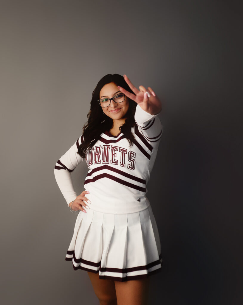 Senior girl giving the peace sign in a tulia high school cheer uniform