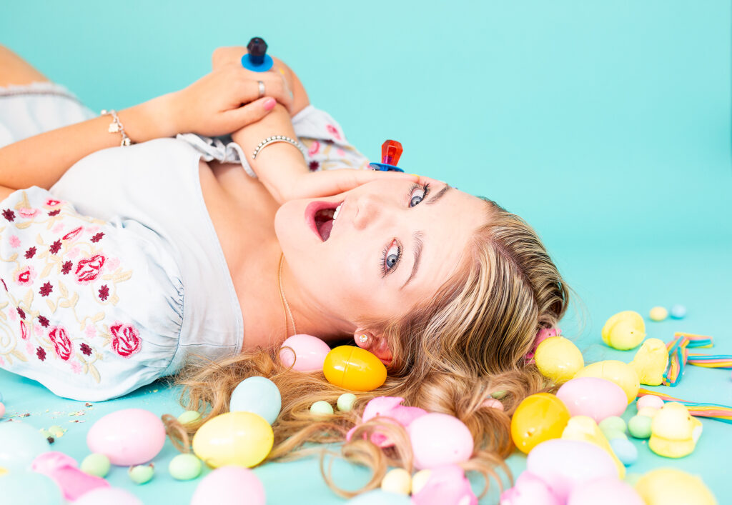 Candy rings and easter candy with a blonde haired senior girl laying down