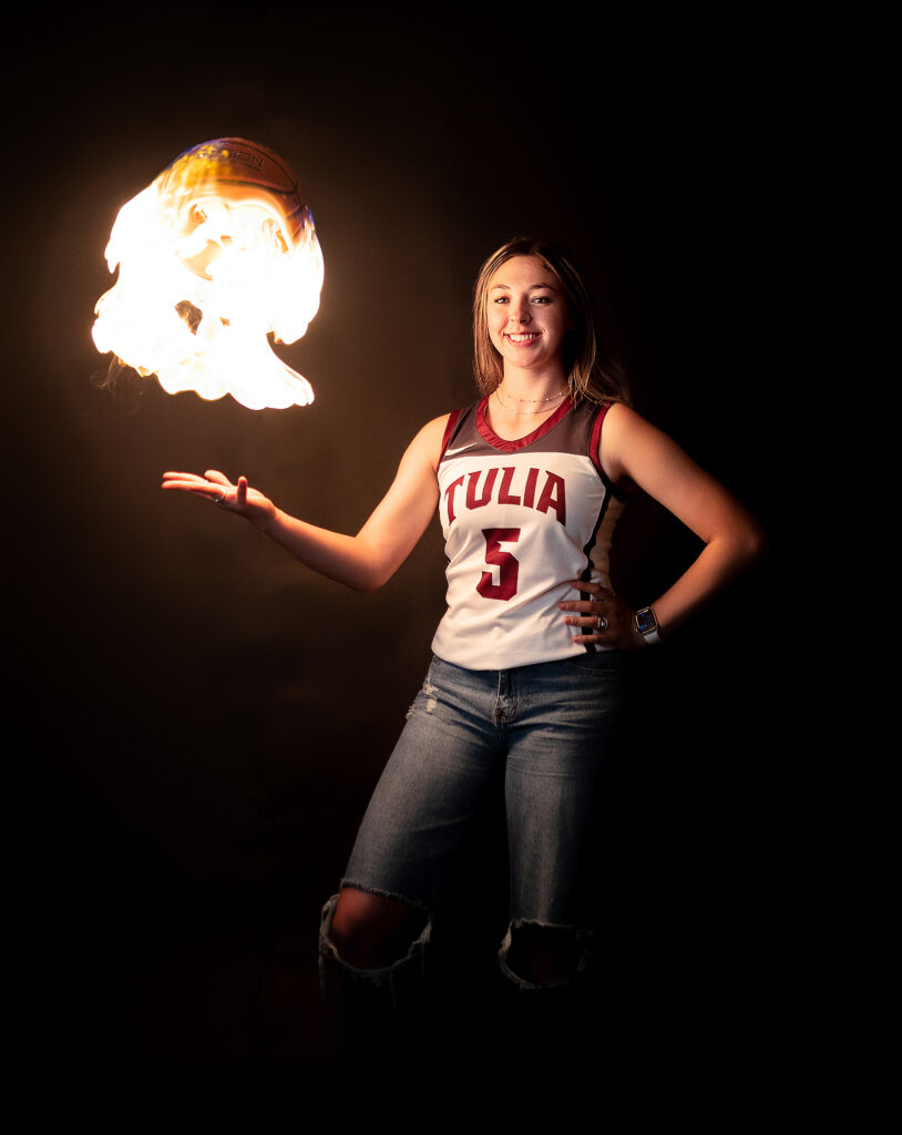 Senior girl throwing a basketball on fire 