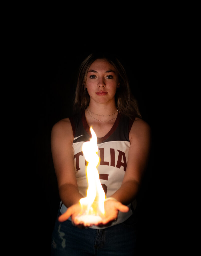 Tulia high school girl in basketball jersey holding fire for her senior session