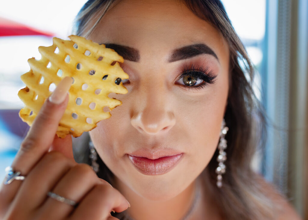 Tulia High School senior holding a Chick-Fil-A waffle fry to her eye while having dinner at the Amarillo restaurant before prom.  